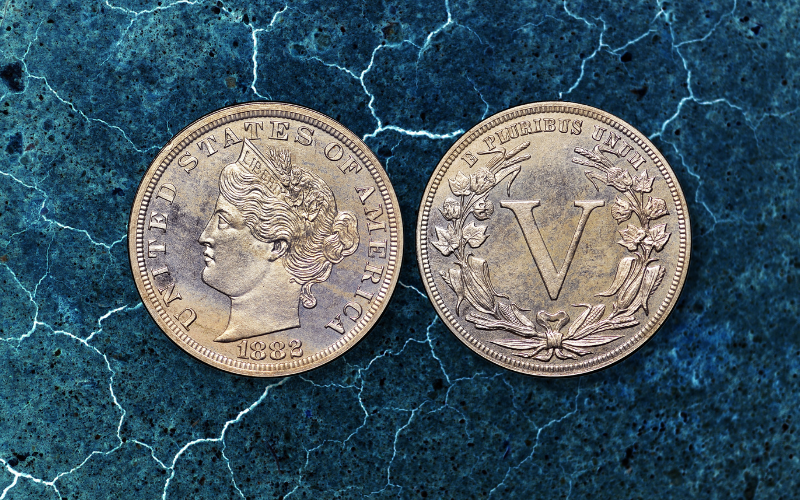Front and back of a liberty head coin over a blue marble background