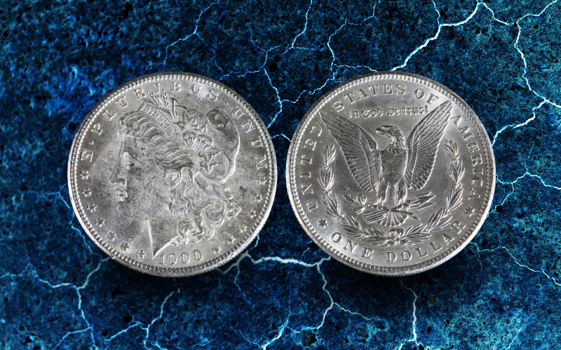 Front and back of a Morgan Silver Dollar over a blue marble background